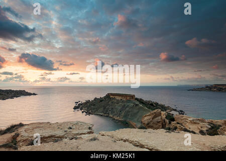 Coucher du soleil à Gnejna Bay sur la côte de Malte. Banque D'Images