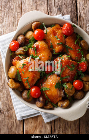 Poulet frit aux châtaignes, verts et tomates close-up dans un bol sur la table. vertical haut Vue de dessus Banque D'Images