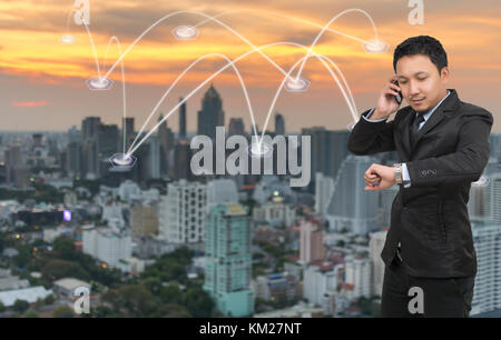 Asian businessman calling téléphone mobile avec connexion réseau sur cityscape background, business connection concept Banque D'Images