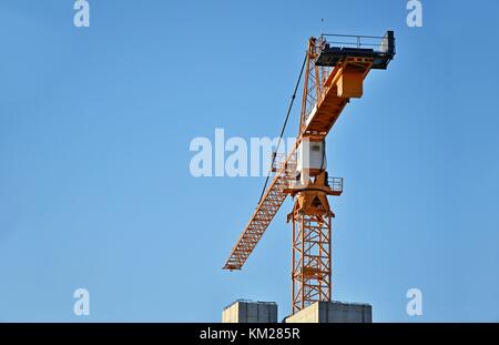Grues de construction unique générique contre un fond de ciel bleu Banque D'Images