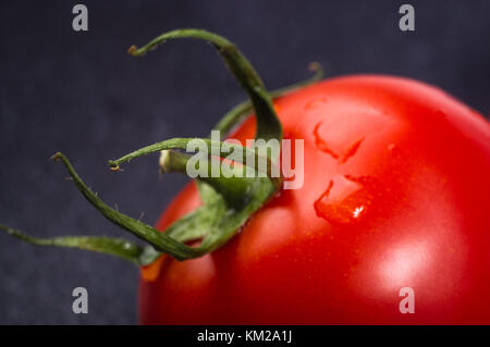 Tomates mûres fraîches sur fond noir, macro photo Banque D'Images