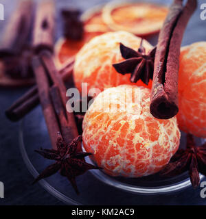 Peler les mandarines sans se coucher sur une plaque avec de l'anis et de baguettes. Carte de Noël. Composition photo, carré aux couleurs Banque D'Images