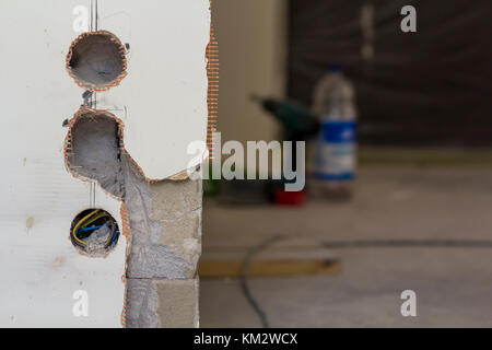 Des trous pour les prises de courant sur le mur au cours de travaux de rénovation Banque D'Images