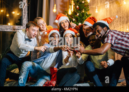 Groupe d'amis heureux de toucher les uns avec les autres verres Banque D'Images
