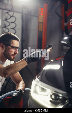 L'homme vérifie le polissage avec une torche Banque D'Images
