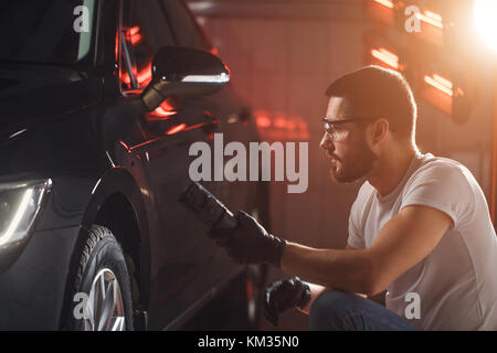L'homme vérifie le polissage avec une torche Banque D'Images