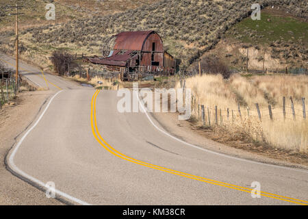 Classic california grange avec la rouille et une route sinueuse Banque D'Images