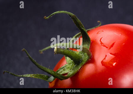 Tomates mûres fraîches sur fond noir, macro photo Banque D'Images