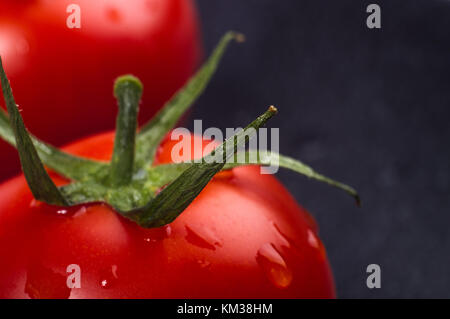 Tomates mûres fraîches sur fond noir, macro photo Banque D'Images