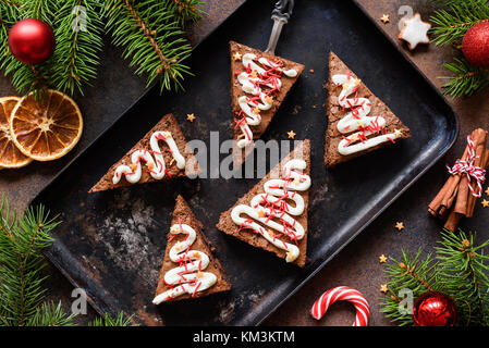 Brownies au chocolat en forme d'arbre de Noël avec le fromage à la crème et saupoudre de fête. Vue d'en haut. Noël sucré ou les vacances d'hiver, l'alimentation Banque D'Images