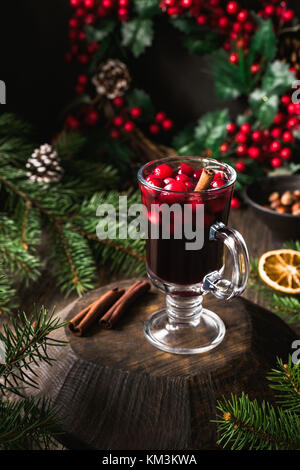 Vin chaud aux canneberges et la cannelle en verre sur planche de bois. Noël chaud boire, toujours la vie. Selective focus Banque D'Images