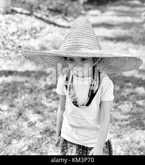 Jeune fille portant un sombrero marche dans une rue de banlieue, Townsville, Queensland, Australie Banque D'Images