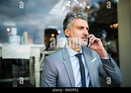 Businessman with smartphone dans une piscine hôtel cafe. Banque D'Images