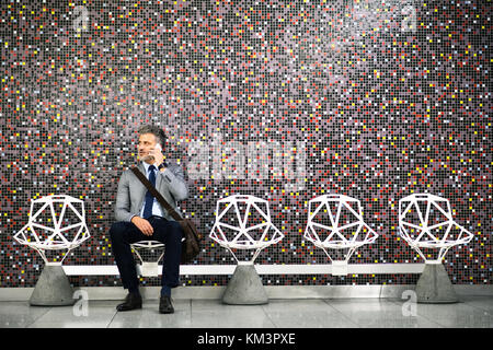 Man avec le smartphone dans une station de métro. Banque D'Images