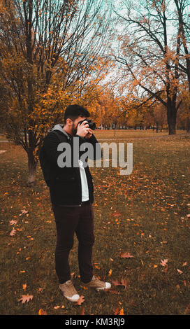 Photos de tournage de l'homme dans un parc forestier avec des feuilles jaunes avec un sac à dos sur son dos instagram horizontal modifier Banque D'Images