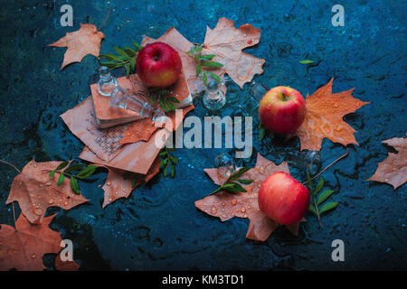 Automne Nature morte avec pommes, les feuilles tombées, pièces d'échecs et de gouttes d'eau sur un fond de pierre Banque D'Images