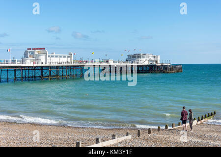 Jeune couple sur plage et jetée de Worthing, Worthing, West Sussex, Angleterre, Royaume-Uni Banque D'Images