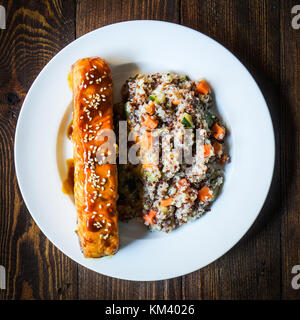 Saumon au four avec du couscous et des légumes sur fond de bois Banque D'Images