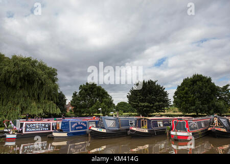 Rangée de narrowboats amarré fin sur le long du canal de Coventry, Staffordshire, Angleterre. Banque D'Images