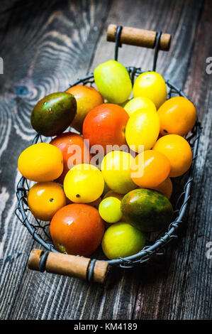 Tomates colorées sur fond de bois Banque D'Images