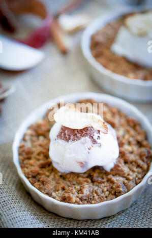 Dessert crumble aux pommes à la cannelle et crème glacée à la vanille sur fond de bois Banque D'Images