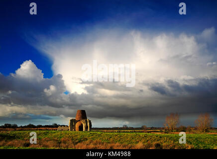 Une vue de douche lourde nuages sur les ruines de l'abbaye St benet gatehouse et drainage mill à Horning, Norfolk, Angleterre, Royaume-Uni. Banque D'Images