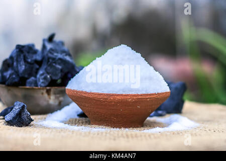 Chlorure de sodium, le sel dans un bol d'argile avec du charbon. Banque D'Images