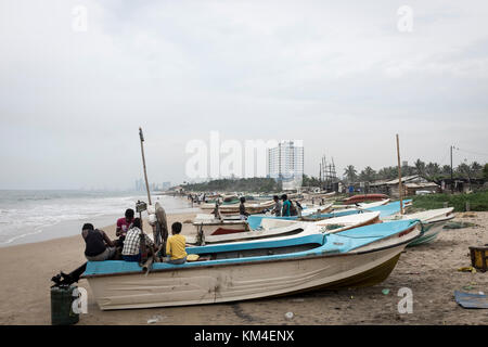 Les pêcheurs ont tendance à leurs bateaux sur la plage de Colombo, Sri Lanka Banque D'Images