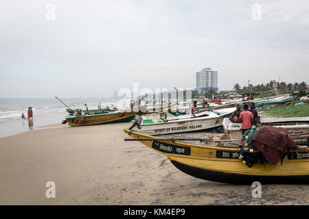 Les pêcheurs ont tendance à leurs bateaux sur la plage de Colombo, Sri Lanka Banque D'Images