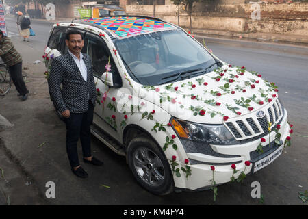 Le punjabi époux se tient à côté d'un véhicule utilitaire sport de mariage décorées de roses à Amritsar, Inde Banque D'Images