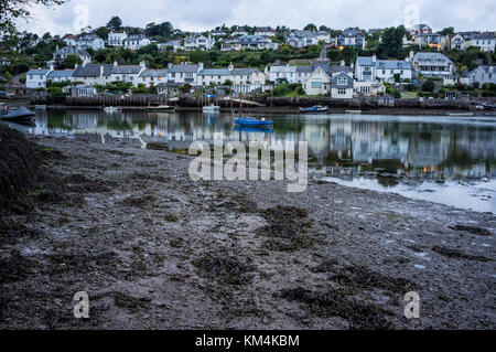 Un petit port abrité et d'amarrage pour bateaux. maisons de la colline surplombant la baie, et les lumières à la tombée de la nuit. Banque D'Images