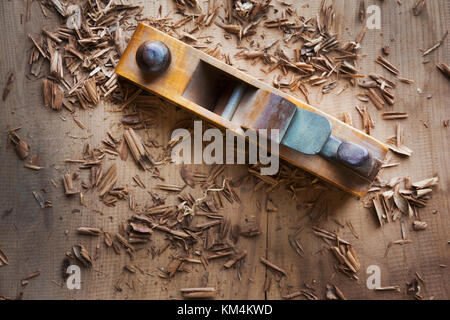Un avion de bois sur la surface d'un morceau de bois, copeaux éparpillés. Banque D'Images