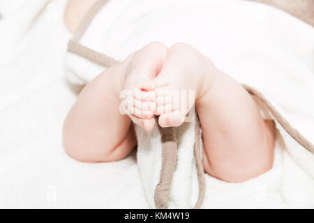 Les jambes de bébé sur le lit, soft focus nouveau-né petits pieds, le bas du corps. close up photo de bébé nouveau-né pieds sur une feuille blanche. Banque D'Images