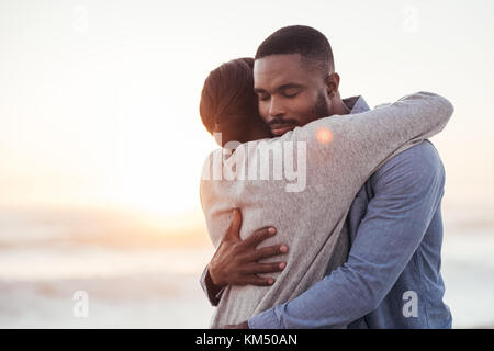 Content young African couple hugging at the beach Banque D'Images