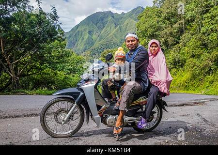 Famille indonésienne avec un tout-petit en moto à travers la forêt tropicale de pluie sur les pentes du mont Rinjani, volcan sur l'île de Lombok, Indonésie Banque D'Images