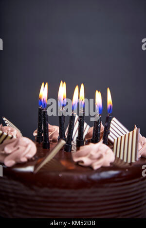 Gâteau d'anniversaire chockolate avec bougies sur fond noir libre Banque D'Images