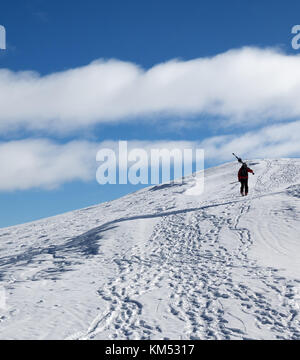 Avec skieur skis sur l'épaule allez jusqu'au haut de la montagne enneigée au soleil froid 24. Montagnes du Caucase en hiver, la Géorgie, la région Gudauri, Mt. Kudebi. Banque D'Images