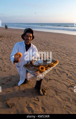 Agadir, Maroc, 22 octobre 2017 : un homme fait don de la maison de vente sur la plage par l'océan atlantique. Banque D'Images