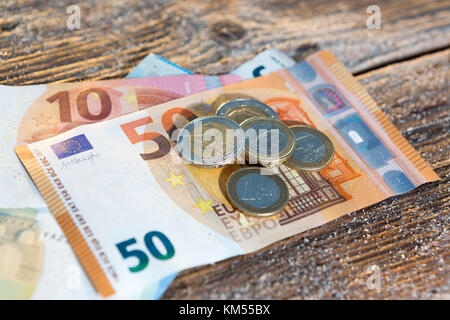 Euro 50 et 10 projets de loi avec la monnaie - l'argent comptant, journée ensoleillée sur le bois dans une ambiance de lumière au coucher du soleil Banque D'Images