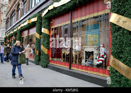 Knightsbridge. Londres, Royaume-Uni. 9Th jul 2017. un nouveau client l'exécution harrods panier passe devant la vitrine de Noël harrods qui est conçu par Dolce & Gabbana. Ses couleurs de l'image attire des milliers de visiteurs pour la saison des festivals. crédit : dinendra haria/Alamy live news Banque D'Images