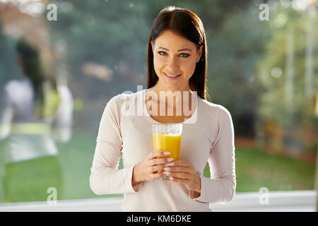 Jeune fille tenant un verre de jus d'orange Banque D'Images