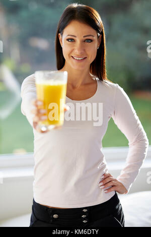 Jeune fille tenant un verre de jus d'orange Banque D'Images