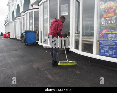 Un homme balaie les allées sur South Parade Pier, Southsea, Portsmouth, Angleterre Banque D'Images