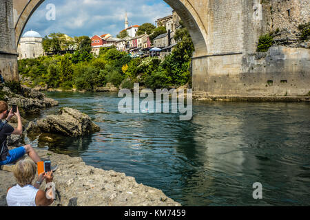 Un plongeur nage après avoir sauté de l'ancien pont sur la Neretva à Mostar, Bosnie-Herzégovine Banque D'Images