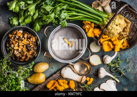 Les champignons des forêts sur la préparation de la table de cuisine rustique avec marmite vide et légumes, top view concept de cuisine d'automne. Banque D'Images