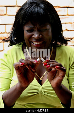 Femme africaine briser une cigarette dans la moitié Banque D'Images