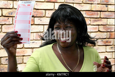 African woman holding un billet de loterie Banque D'Images