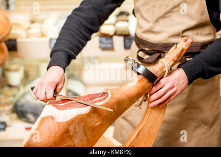 Le découpage au long couteau dans la jambe de prosciutto food store Banque D'Images