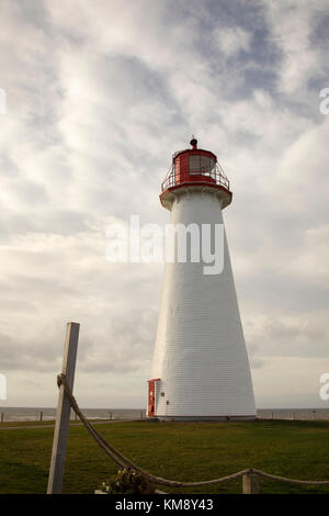 Phare de Point Prim sur l'Île du Prince Édouard, Canada contre un ciel bleu nuageux aux beaux jours. Banque D'Images