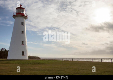 Phare de Point Prim sur l'Île du Prince Édouard, Canada contre un ciel bleu nuageux aux beaux jours. Banque D'Images